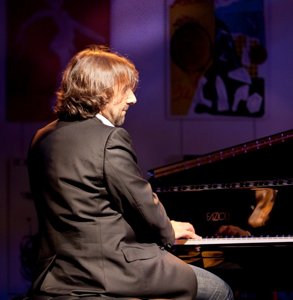 Pianiste sur scène devant un piano à queue